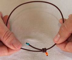 two hands holding onto a cord with beads on it