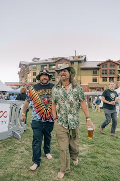 two men standing next to each other in the grass