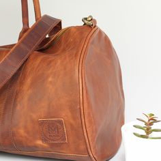 Leather duffle bag in vintage brown. Vintage Leather Duffle Bag With Soft Leather, Vintage Soft Leather Duffle Bag, Everyday Cognac Duffle Bag With Leather Lining, Everyday Leather Lined Tote Duffle Bag, Everyday Leather-lined Tote Duffle Bag, Vintage Leather Duffle Bag With Leather Trim, Vintage Leather Weekender Bag With Leather Lining, Everyday Leather Duffle Bag, Everyday Cognac Soft Leather Duffle Bag