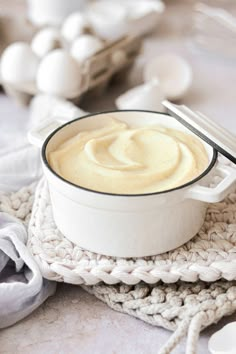 a white bowl filled with cream sitting on top of a crocheted place mat