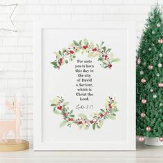 a christmas tree next to a framed print with the bible verse on it and a small pine tree