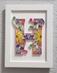 the letter h is made out of paper flowers and button buttons on a white frame