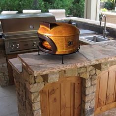 an outdoor bbq grill sitting on top of a stone counter