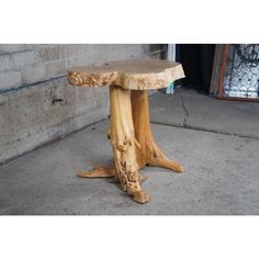 a wooden table sitting on top of a cement floor next to a wall and door