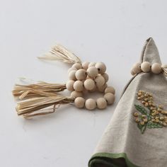 two small wooden beads are sitting next to a cloth bag