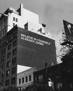 black and white photograph of an advertisement on the side of a building