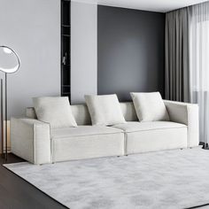 a living room with a white couch and floor lamp next to the window in front of it