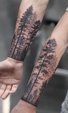 two arm tattoos with trees on them