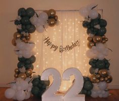 a decorated birthday arch with balloons and streamers in the shape of numbers twenty two