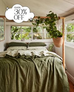 the bed is made with green linens and has a sale sign above it that says 30 % off