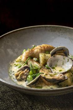 a bowl filled with pasta and clams on top of a table