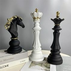 three chess pieces are sitting on top of each other, one is black and the other is white