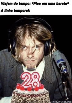 a man wearing headphones and holding a cake with the number twenty two on it