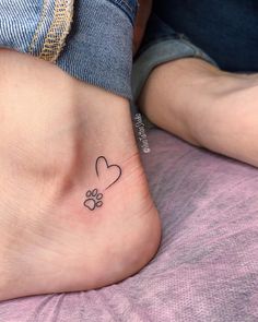 a small heart and paw tattoo on the ankle