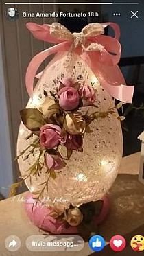 a vase filled with pink flowers on top of a wooden table next to a cell phone