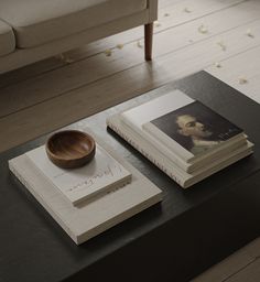 two books and a bowl on a coffee table