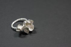 -Product description- Handmade sterling silver (925) jasmine ring. The ring shank is handmade with twisted and beaded wire. The inner surface of the jasmine petal was carefully hand textured to be shimmery. While the outer layer was smooth and shiny, to give a beautiful contrast. A freshwater pearl was then attached to give an elegant touch. Great as a gift for her, or a treat for yourself. The jasmine blossom and bud part are about 25mm in length (1 inch) and 17mm (11/16 inch) in width, weighin Delicate Silver Pearl Ring Gift, Handmade Delicate Silver Flower Ring, Delicate Handmade Silver Flower Ring, Handmade Elegant Silver Flower Ring, Adjustable Delicate Silver Pearl Ring, Elegant Handmade Silver Flower Ring, Handmade Sterling Silver Flower Ring For Wedding, Handmade Silver Flower Ring, Elegant Handmade White Gold Flower Ring