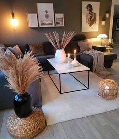 a living room with couches, tables and candles on the coffee table in front of them