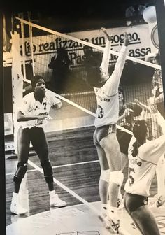 an old black and white photo of two men playing volleyball