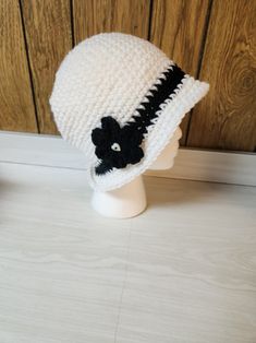 Add a unique and stylish touch to your winter or fall wardrobe with this handmade crochet bucket hat. The hat features a white and black color combination, making it a perfect match for your casual outfits. It is made from high-quality acrylic material and crochet fabric type with beautiful accents that add to its overall charm. This bucket hat is suitable for adults and is perfect for women who love the boho theme. The hat is carefully crafted in the United States, and it is ready to be shipped Adjustable White Crochet Bucket Hat, White Adjustable Crochet Bucket Hat, Black Crochet Yarn Bucket Hat, Black Yarn Crochet Bucket Hat, White Short Brim Bucket Hat For Winter, White Winter Bucket Hat With Short Brim, White Yarn Bucket Hat With Short Brim, Casual White Brimmed Crochet Hat, White Brimmed Bucket Hat For Winter