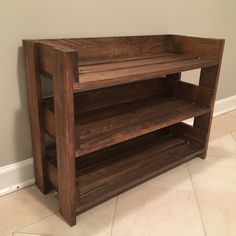 a wooden shelf sitting on top of a tiled floor