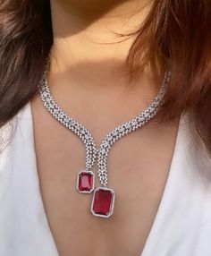 Gorgeous fine quality lab diamonds studded necklace with Ruby red stones in white gold rhodium plating and matching Earrings Item contains: Necklace and earrings  AAA quality cubic zirconia used. Highest quality and craftsmanship Necklace length- 18 inches( adjustable length) Necklace weight-35 gms Earrings length-2 inches  Each earring weighs-7 gms  Closure-Pushback In case of any queries, please feel free to reach out to us. Happy shopping! Bridal Diamond Necklace With 17 Jewels, Diamond Necklace With Jewels, Formal Cubic Zirconia Gemstone Necklace, Formal Gemstone Necklace In Cubic Zirconia, Diamond White Necklace With Jewels, Exquisite Diamond Bridal Necklace With Gemstones, Exquisite Bridal Diamond Necklace With Gemstone, White Gold Diamond Necklace With Jewels, Formal Cubic Zirconia Jewel Necklaces