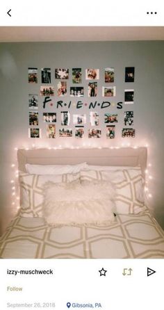 a bed with lights on the headboard and pictures above it that are hanging on the wall