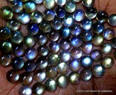 a bunch of black pearls sitting on top of a person's hand