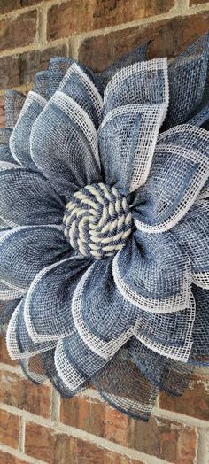 a blue and white mesh flower on a brick wall