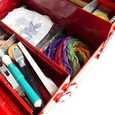 a red box filled with lots of crafting supplies