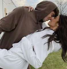 a man and woman are kissing in the grass