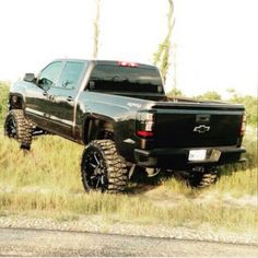 a black truck is parked in the grass