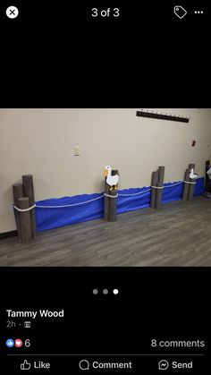 an empty room with blue tarp covering the floor and two wooden posts in front of it