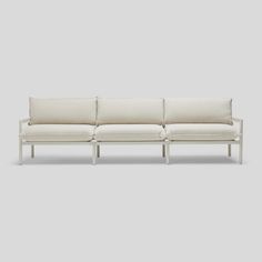 a white couch sitting on top of a gray floor