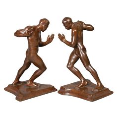 two bronze figurines of men playing with each other