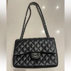 This Chanel Shoulder Bag Is A Timeless Classic, Crafted From Black Quilted Lambskin Leather With Silver Hardware Accents. The Authentic Bag Id# 19277509 The Bag Features A Rectangular Shape With A Turn Lock Closure And Double Handles For Easy Carrying. It Has A Large Size With A Depth Of 3.75 Inches, A Width Of 12 Inches, And A Height Of 8 Inches. The Bag Has Four Inside Pockets And One Outside Pocket, Providing Ample Space For Your Essentials. It Also Comes With A Chain Strap That Can Be Adjusted To A Drop Of 12.75 To 23.5 Inches. The Bag Is Adorned With Silver Stitching Accents And Chanel's Signature Burgundy Leather Lining. This Classic Double Flap Shoulder Bag Is A Must-Have For Formal Soft Leather Bag With Double Flap, High-end Bags With Cc Turnlock Closure And Double Flap, High-end Travel Shoulder Bag With Cc Turnlock Closure, Everyday Clutch Bag With Cc Turnlock Closure, Clutch Bags With Cc Turnlock Closure For Everyday, Elegant Double Flap Bag With Dust Bag Included, Cc Turnlock Clutch Bag, Luxury Business Shoulder Bag With Double Flap, Luxury Office Bag With Double Flap