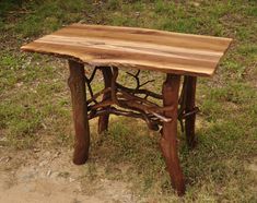 a small wooden table sitting on top of a grass covered field