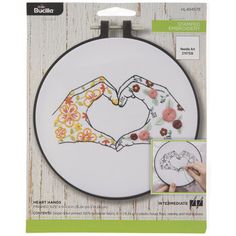 the embroidery kit has two hands making a heart