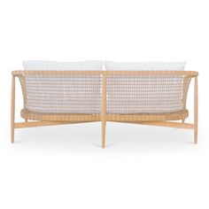 two wicker couches with white pillows on each side and one in the middle