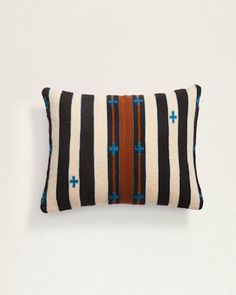 a black and white striped pillow with blue crosses on it