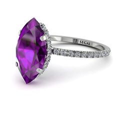 an engagement ring with a large purple stone surrounded by white diamonds on the band and side stones