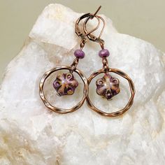 Cottagecore style light purple beads and copper ring dangle earrings. Lightweight Bohemian Czech glass bead dangle earrings with a twisted copper finished ring accent. Beautiful alabaster violet flower beads will add a pop of color to your outfits.   Artisan glass beads produced in small quantities in the Czech Republic Hypoallergenic ear wires (nickel and lead free). Select ear wire style at checkout. A gift for you or someone special, earrings are carded and in an organza bag. Link back to my Copper Wire Dangle Jewelry For Jewelry Making, Bronze Wire Wrapped Czech Glass Earrings, Copper Jewelry With Matching Round Bead Earrings, Adjustable Copper Flower Jewelry, Bronze Czech Glass Dangle Jewelry, Adjustable Circular Copper Jewelry, Copper Beaded Dangle Earrings As Gift, Copper Beaded Dangle Earrings, Czech Glass Hoop Earrings As Gift