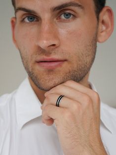 a man wearing a white shirt and black ring