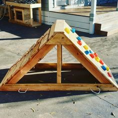 a child's play structure made out of wood with balls on the top and bottom