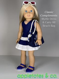 a doll wearing sunglasses and a blue dress with white trim, standing in front of a gray background