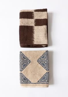 two brown and white towels sitting next to each other on top of a white surface