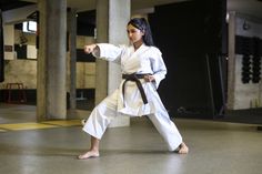 a woman is practicing karate in a gym