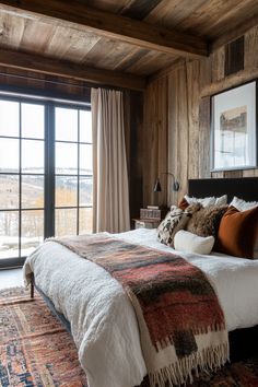 a bedroom with wood paneled walls and large windows