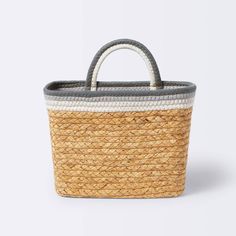 a small basket with handles and two tone stripes on the bottom, sitting against a white background