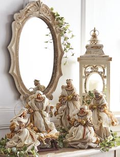 a group of figurines sitting on top of a mantle next to a mirror